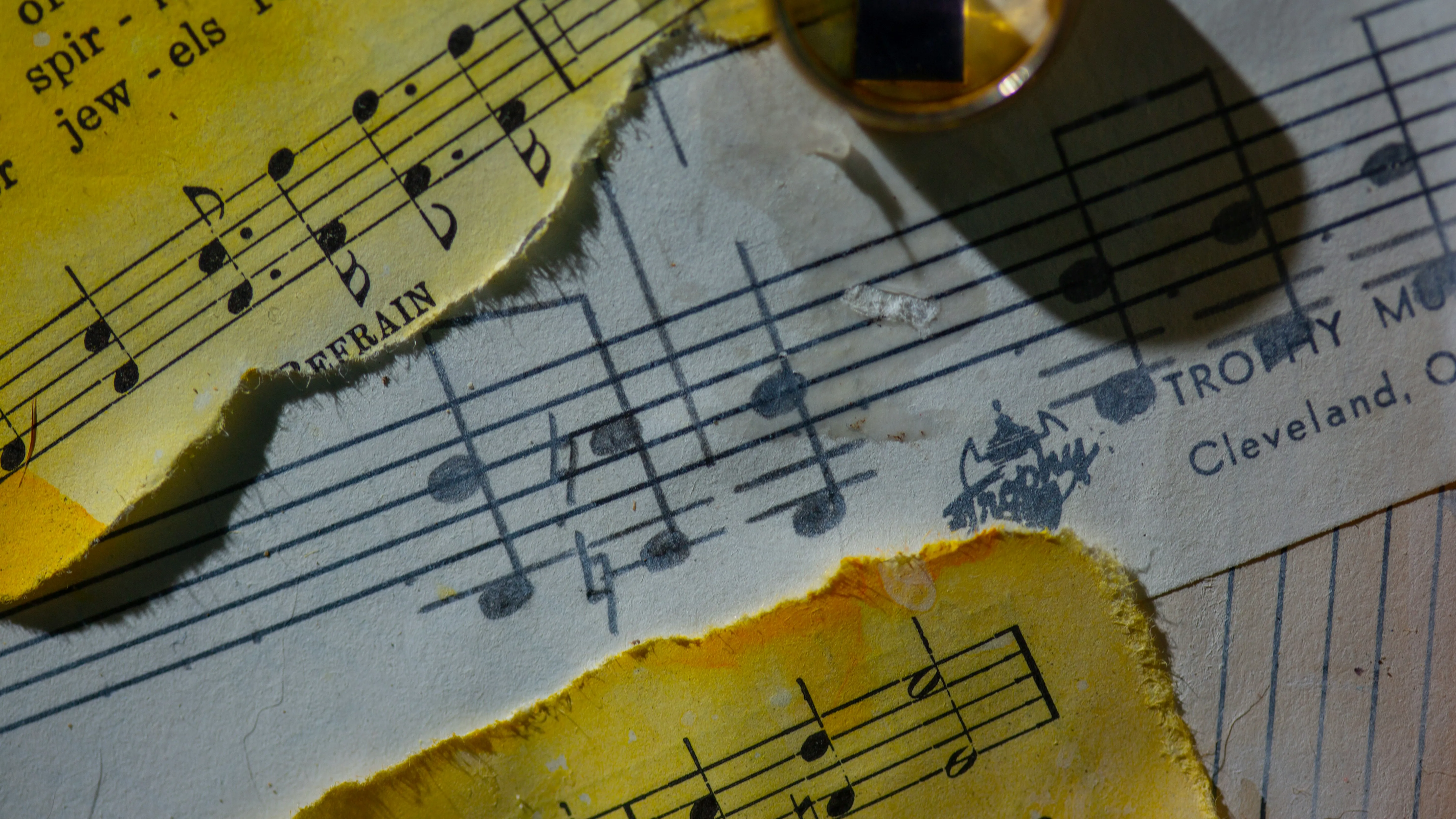 Yellowed sheet music fragments over penciled sheet music with erasure smudges